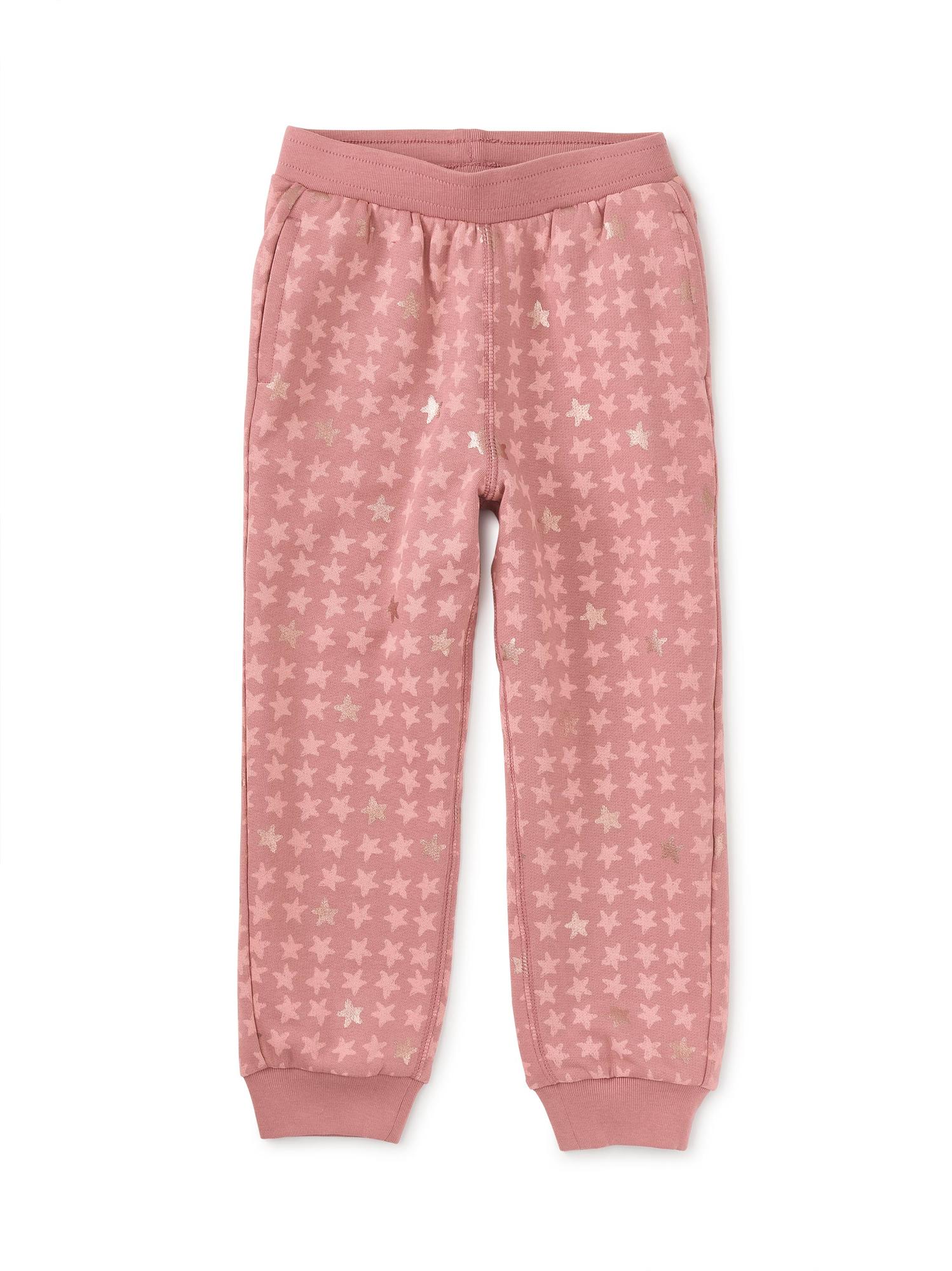 A pair of pink metallic stars joggers for girls, featuring an elastic waistband and fully functional interior drawcord.