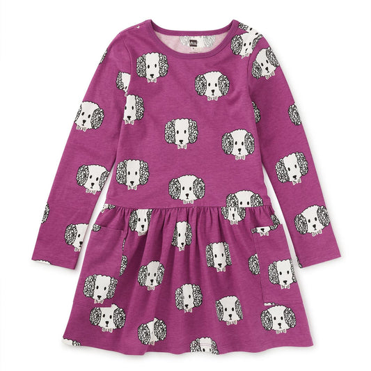 A long sleeve purple dress with a crew neckline and patch pockets, featuring a dog pattern.
