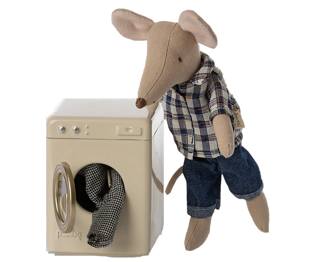 Stuffed mouse toy in plaid shirt and jeans standing next to a toy washing machine on a white background