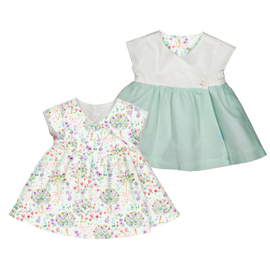 Reversible baby's dress, one floral and one solid color, on a white background.