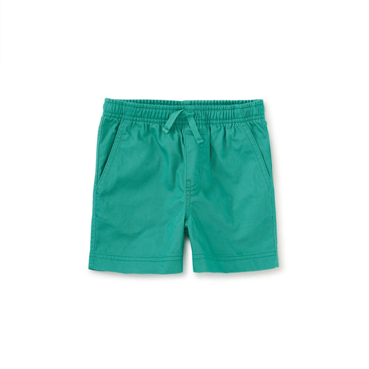 Mid-thigh length green sport shorts with an elastic waistband and drawcord, featuring slash front pockets and a back patch pocket.