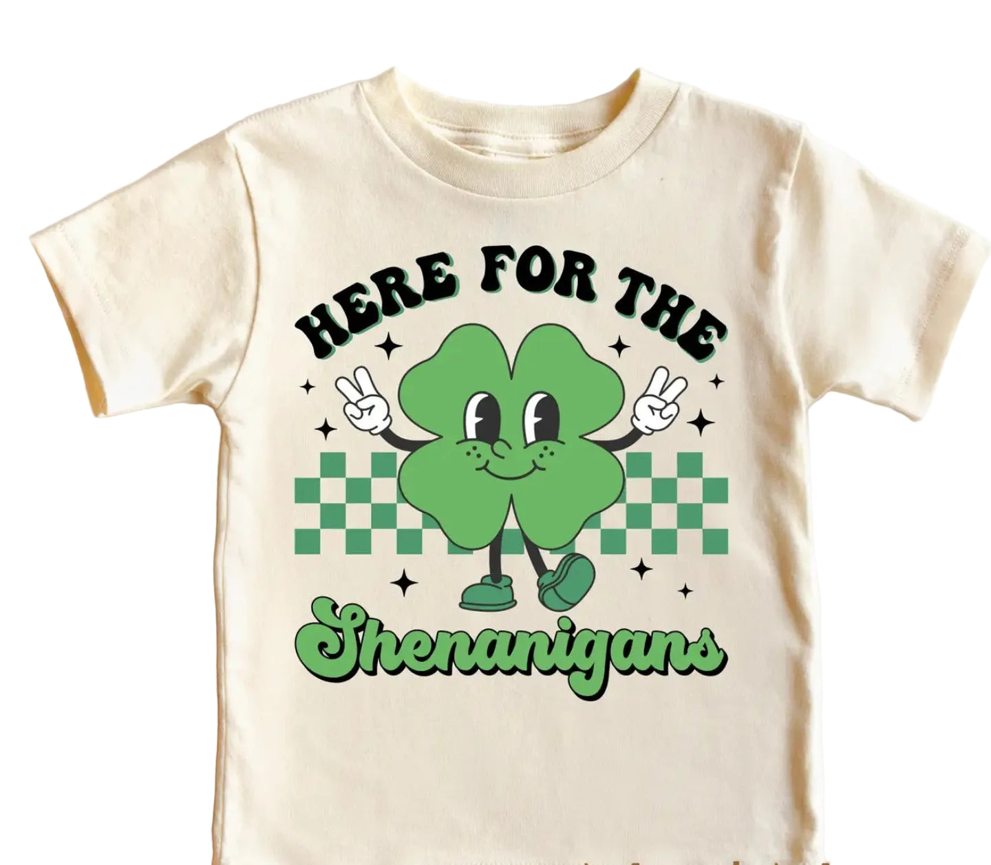 Beige t-shirt with green cartoon clover and text 'Here for the Shenanigans' on a white background, branded with Madi Moosh.