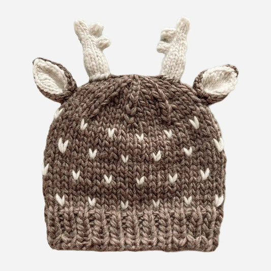 A brown and cream knit baby hat designed like a deer, featuring a textured brown body with cream-colored antlers and ears, shown against a plain light gray background.