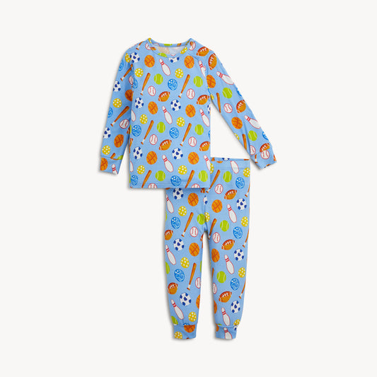 A two-piece baby pajama set featuring a long-sleeve top and matching pants in light blue, covered in an all-over baseball-themed print with balls, bats, and fielding accessories in orange, yellow, green, white, and blue.