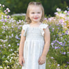 Young girl in a white dress standing in a field of flowers