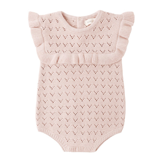 Pink knitted baby romper with ruffled details on a white background