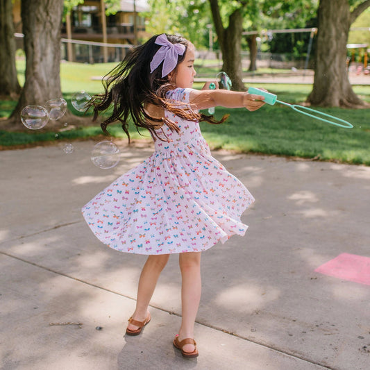 Light pink twirl dress with multi color butterflies