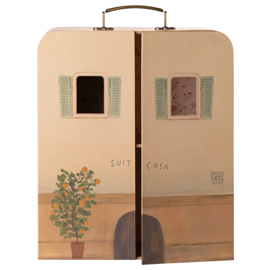Suitcase with artistic design of a house, plant, and shutters on a white background