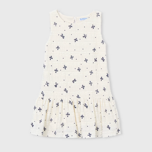 Cream dress with bow pattern.