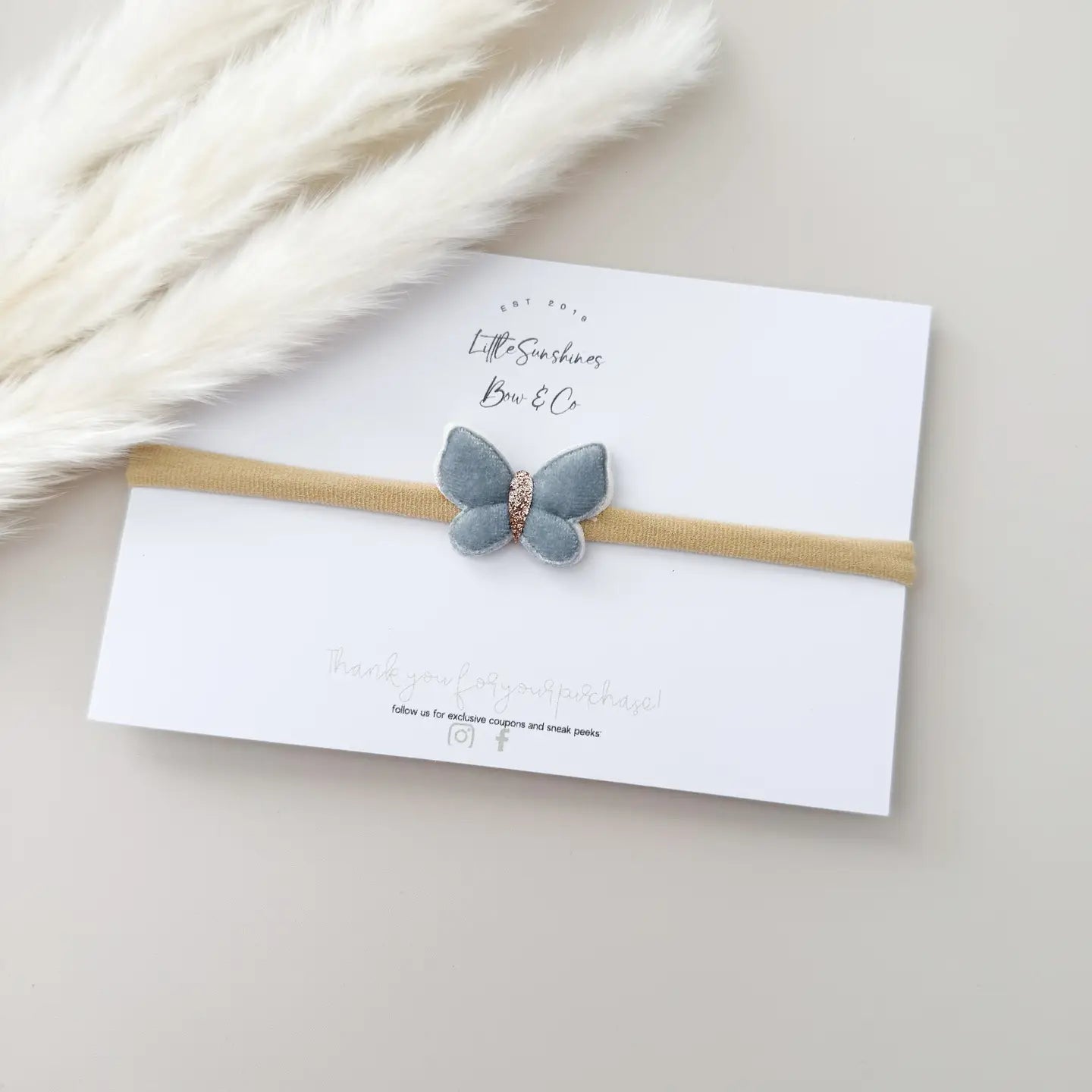 Butterfly headband on a white card with a soft background
