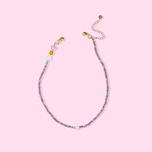 Beaded necklace with colorful beads on a pink background