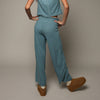 A model shown from behind wearing a matching light blue short-sleeve top and wide-leg pants set.