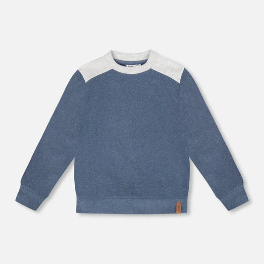 Blue sweater with white sleeves on a light gray background