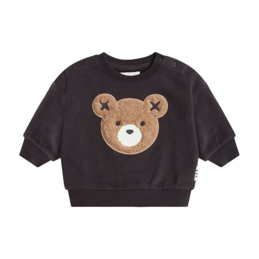 Black sweater with a bear face design on a beige background