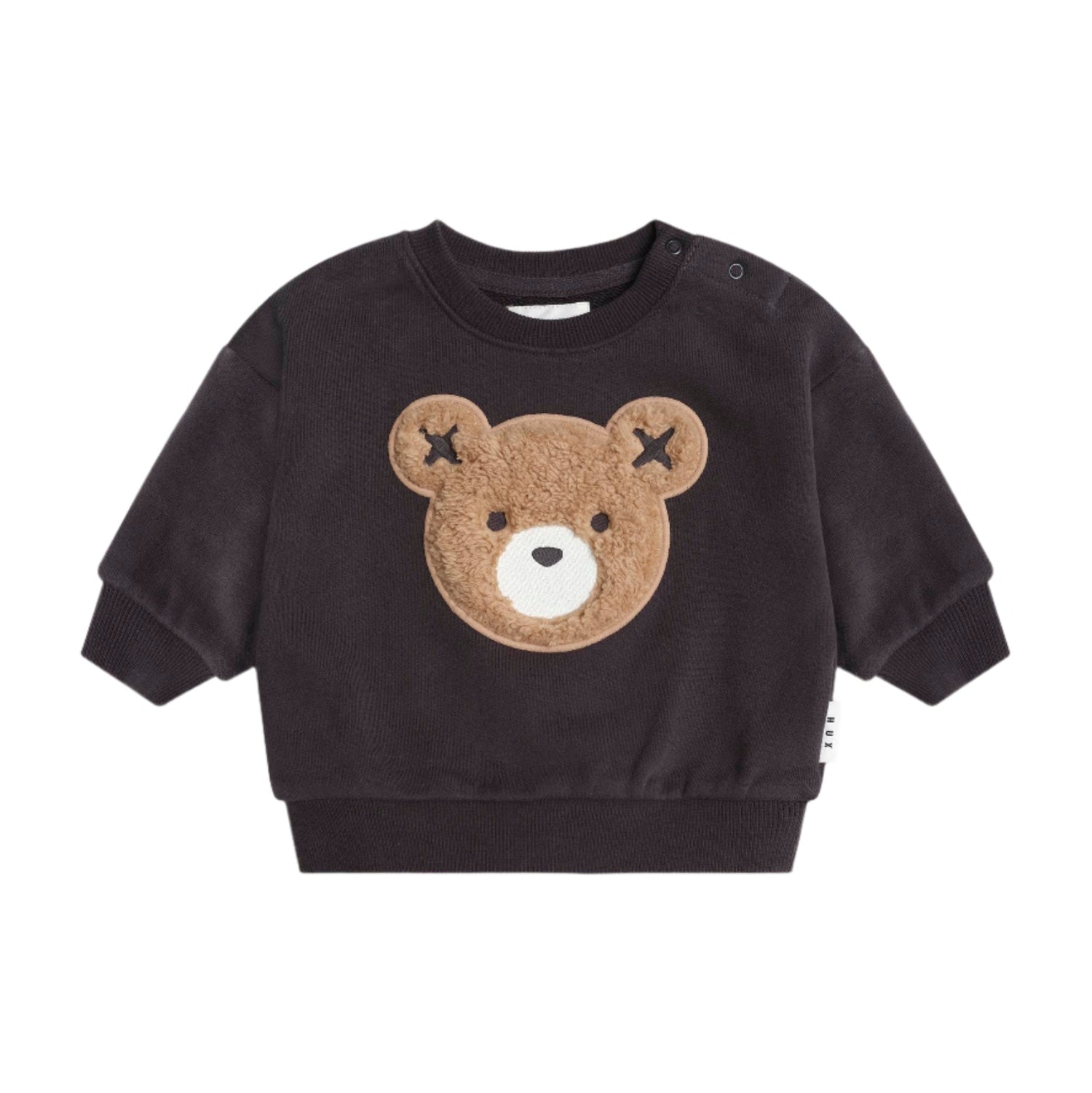 Black sweater with a bear face design on a beige background