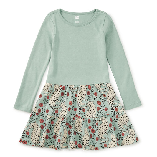 Green long-sleeve top with a patterned skirt on a white background