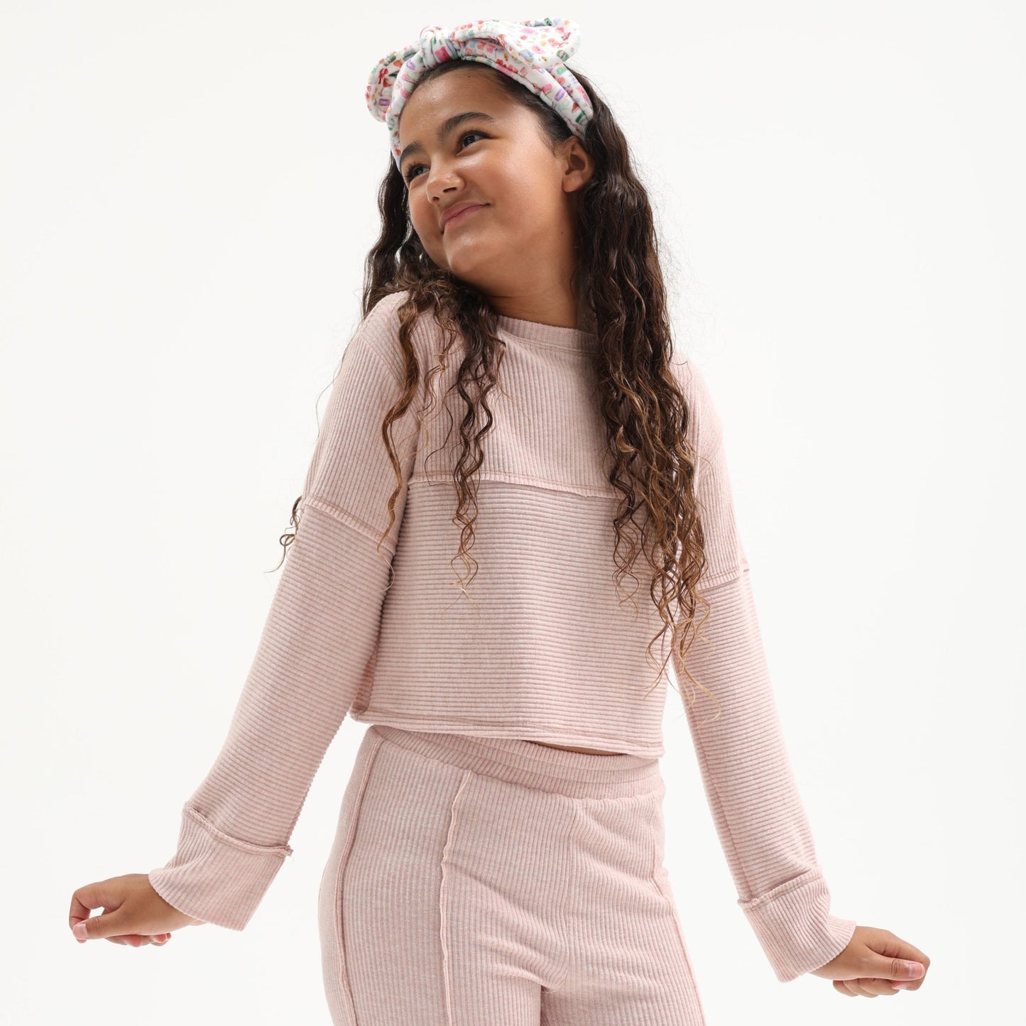 Young girl wearing a pink outfit with a matching headband