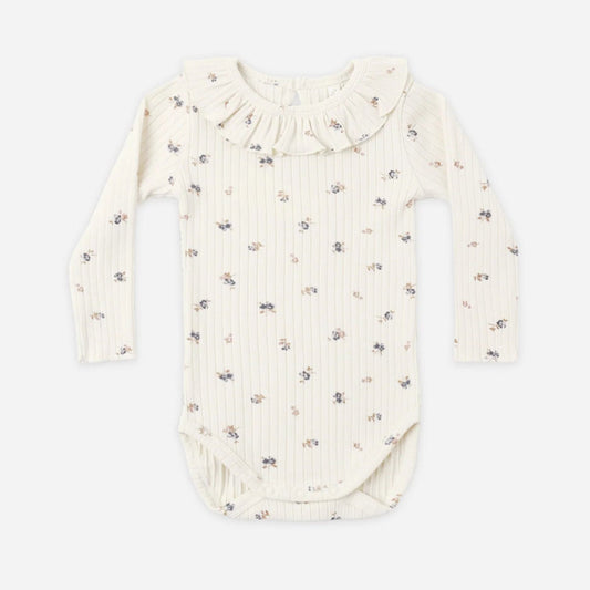 An off-white long-sleeve baby bodysuit with a delicate, small all-over floral print, featuring a ruffled collar and ribbed texture, laid flat against a light gray background.