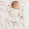 Newborn baby in a white onesie with a gray elephant pattern