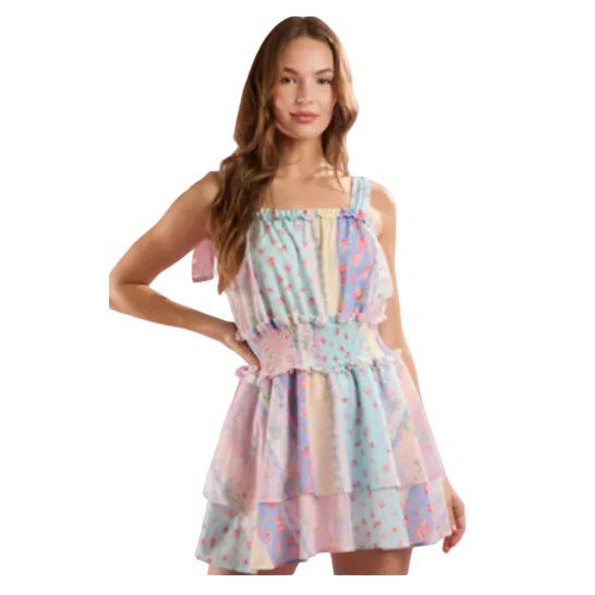 Woman wearing a pastel patterned dress against a pink background