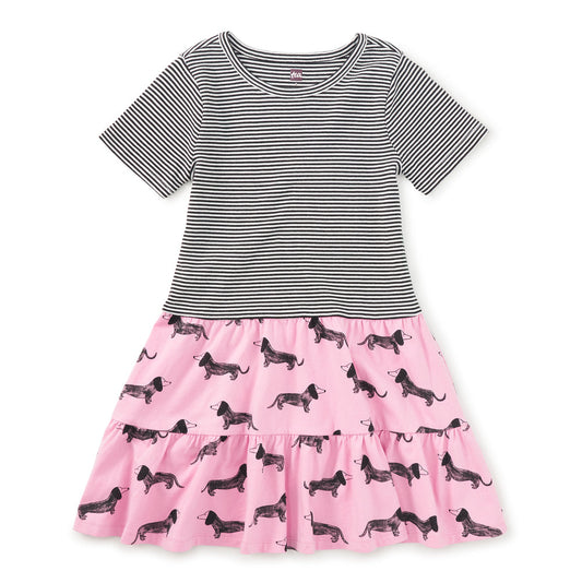Two-tone dress with striped bodice and pink skirt with dog pattern on a white background