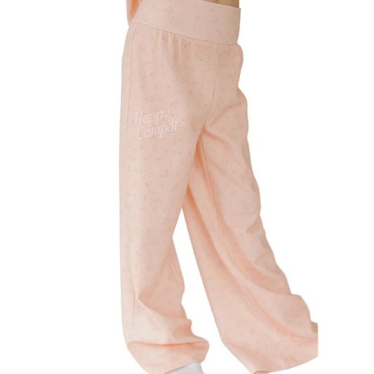 Pink sweatpants with 'Happy Camper' text on a light gray background