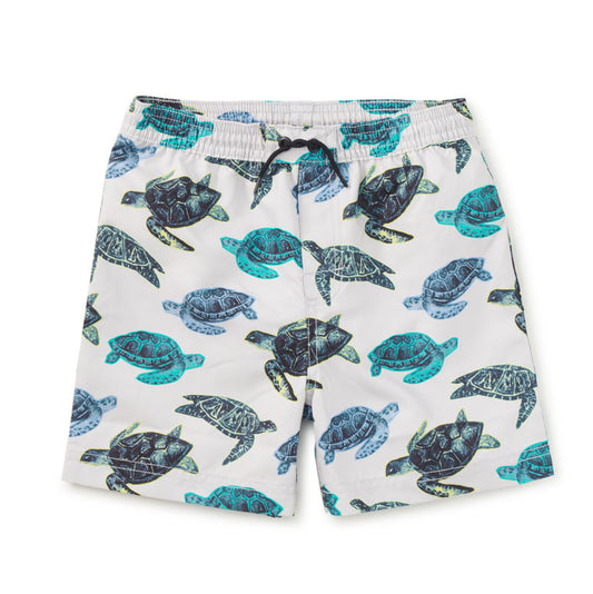 Grey swim shorts with blue turtle pattern on a white background