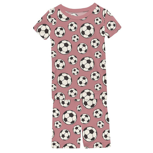 Pink short sleeve pajamas with soccer ball pattern on a pink background