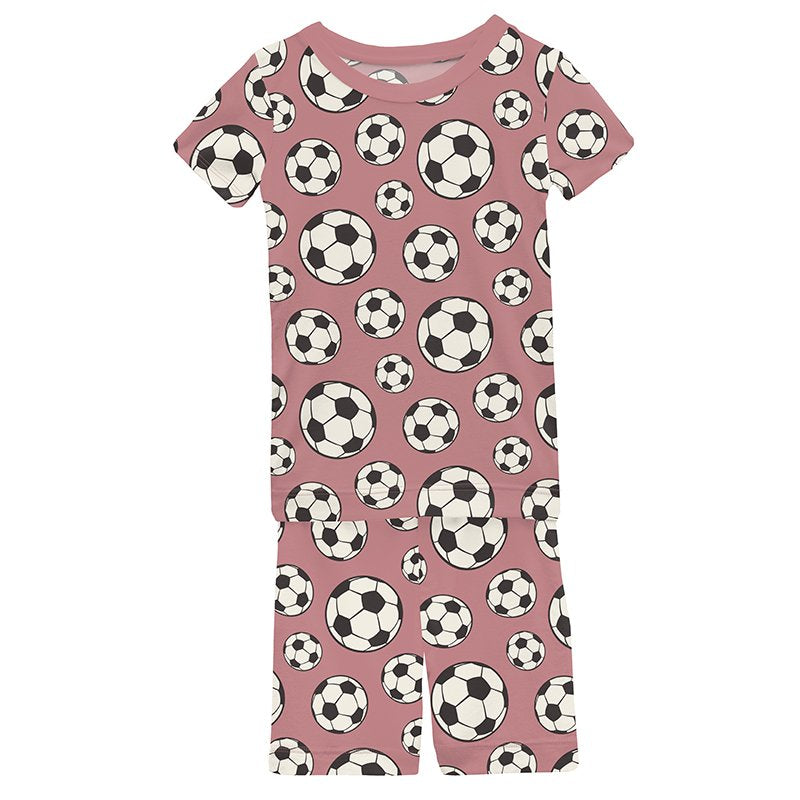 Pink short sleeve pajamas with soccer ball pattern on a pink background