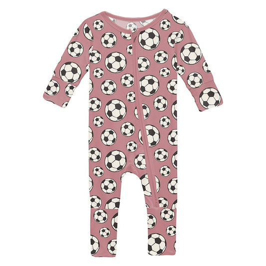 Pink baby romper with soccer ball pattern on a pink background
