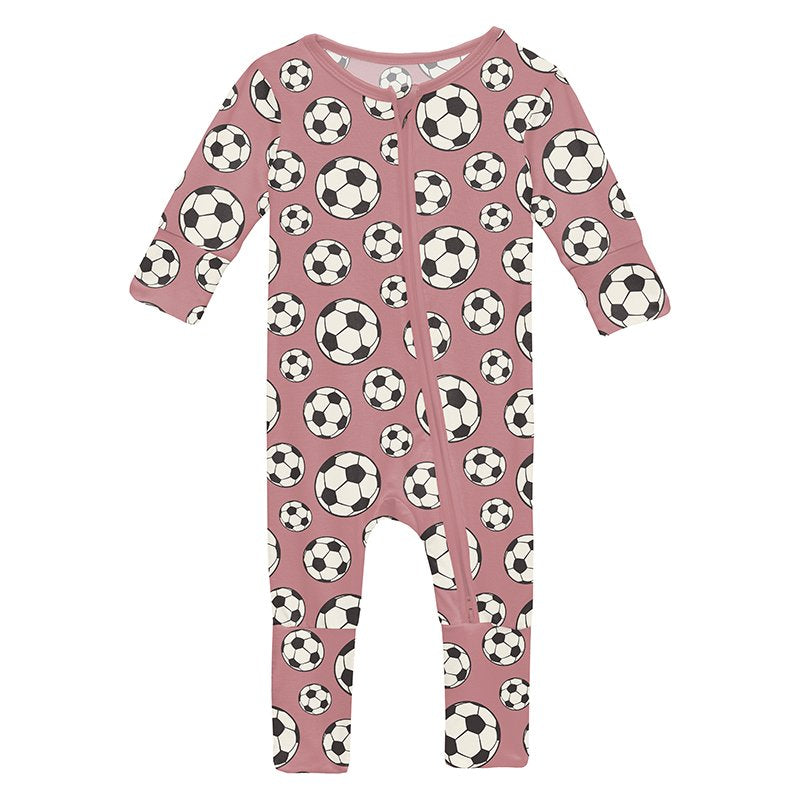 Pink baby romper with soccer ball pattern on a pink background
