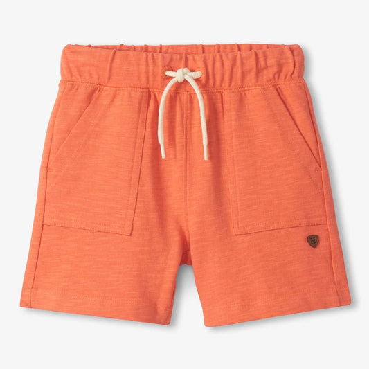 Orange shorts with a drawstring on a light gray background