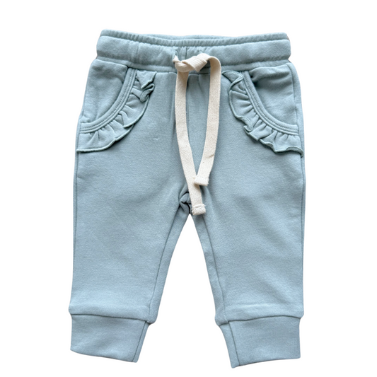 Light blue baby jogger pants with ruffled details on a white background