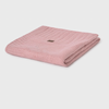 Folded pink knitted blanket on a light gray background
