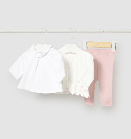 Baby girls three-piece set including a white shirt, pink pants, and a white cardigan on a rack against a white background.