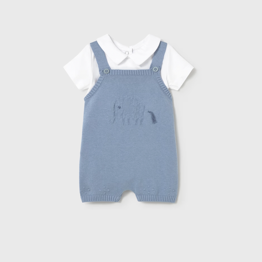 Blue knitted romper with white shirt on a light gray background