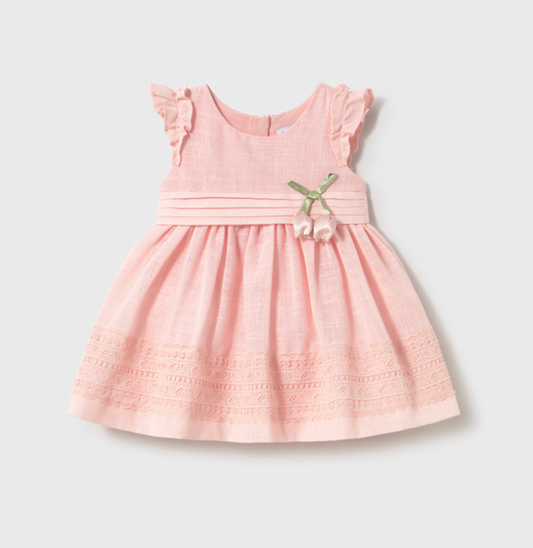 Pink dress with ruffled sleeves and a bow on a light gray background