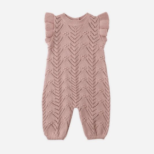 Knitted baby romper with ruffled sleeves on a white background