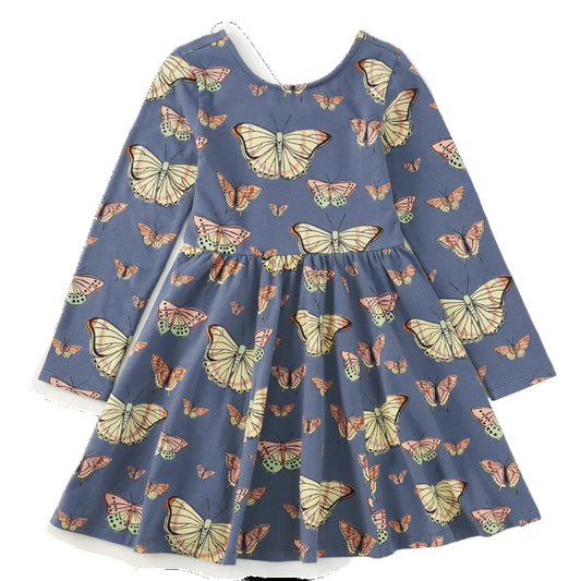 A long-sleeve children's dress in slate blue with an all-over butterfly print, featuring large cream, orange, and green butterflies. The dress has a round neckline, long sleeves, and a gathered empire waist with a flared skirt, shown flat on a white background.