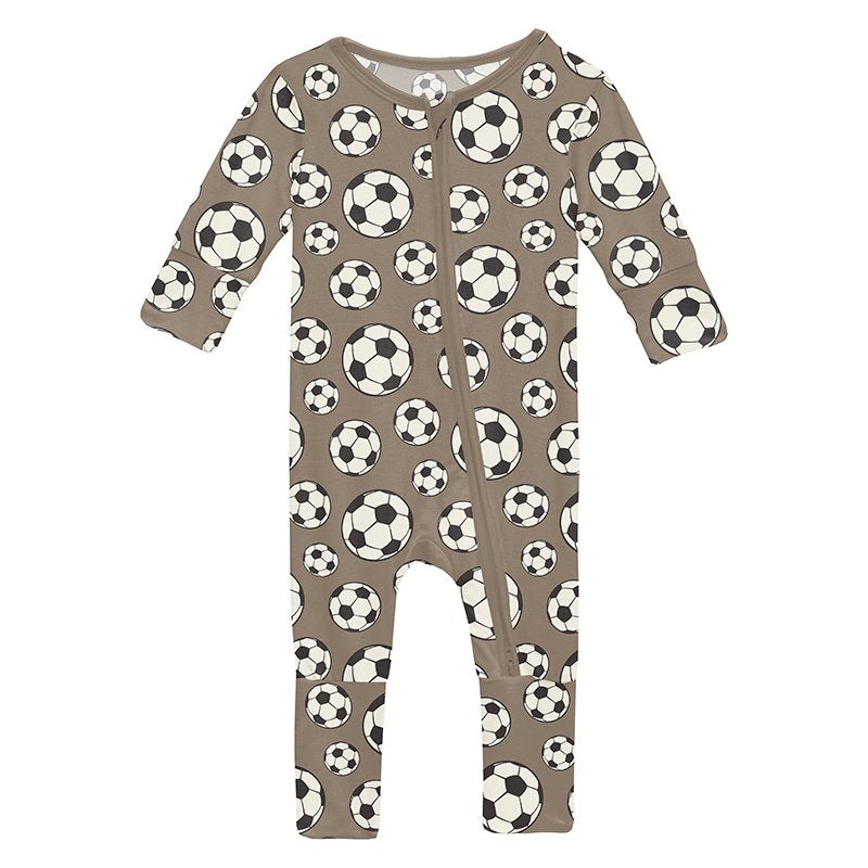 Baby zip footie with soccer ball pattern on a brown background