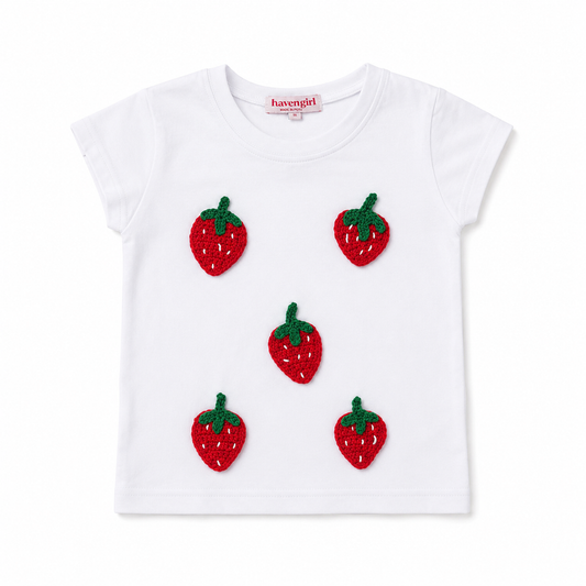 White t-shirt with strawberry appliqués on a white background