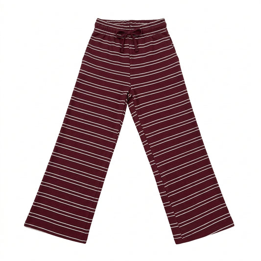 A pair of wide-leg knit pants in burgundy with thin white horizontal stripes, laid flat on a glossy white surface.