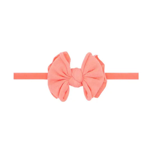 Coral-colored headband with a large bow