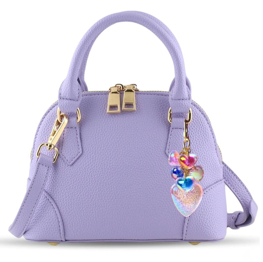 Lavender handbag with gold accents and a colorful heart charm on a white background