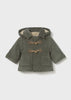 Green baby's coat with brown buttons on a light gray background