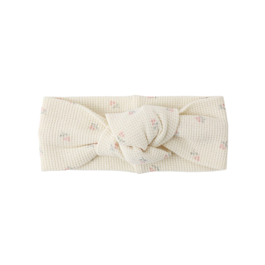 Beige headband with a knot on a white background
