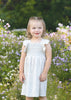 Young girl in a white dress standing in a field of flowers