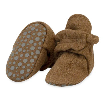 Brown baby booties with textured sole on a white background