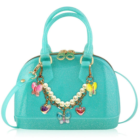 Turquoise handbag with decorative charms on a white background