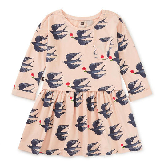 A long sleeve pink dress with a floral and bird pattern, featuring a wrap neckline and a below mid-thigh length.
